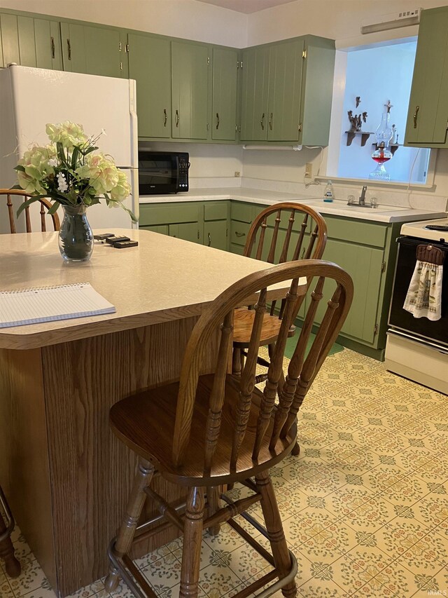 402 Charles St, Union City, IN 47390 - kitchen with freestanding refrigerator, electric range, green cabinets, light countertops, and black microwave