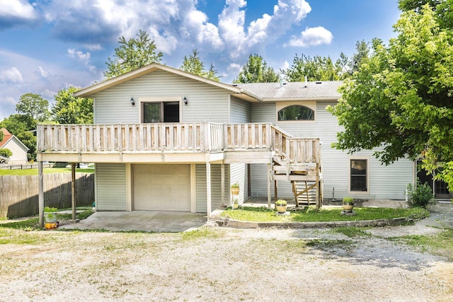 1121 W Grant St, Ellettsville, IN 47429 - rear view of property featuring a garage, a deck, stairway, driveway, and roof with shingles