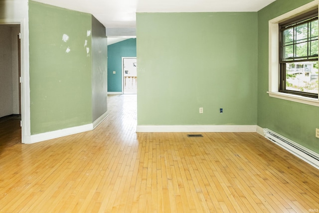 1121 W Grant St, Ellettsville, IN 47429 - empty room with light wood finished floors and a baseboard heating unit