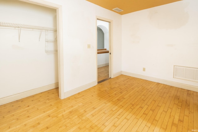 1121 W Grant St, Ellettsville, IN 47429 - unfurnished bedroom with light wood-style flooring, a closet, and arched walkways