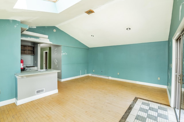 1121 W Grant St, Ellettsville, IN 47429 - unfurnished living room with a baseboard heating unit, a skylight, lofted ceiling, and wood finished floors