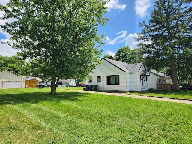 2206 S Hackley St, Muncie, IN 47302 - view of home's exterior featuring a detached garage, a chimney, and a lawn