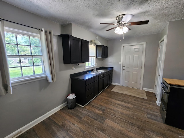 2206 S Hackley St, Muncie, IN 47302 - kitchen with black range oven, dark cabinets, ceiling fan, dark wood-style flooring, and a textured ceiling