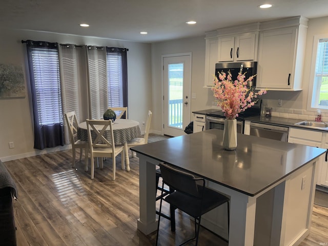 7775 N Hudson Ln, Solsberry, IN 47459 - kitchen with appliances with stainless steel finishes, dark countertops, wood finished floors, white cabinets, and recessed lighting