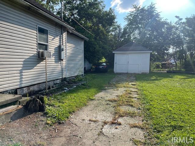 1919 Fletcher St, Anderson, IN 46016 - view of grassy yard featuring a storage shed and cooling unit