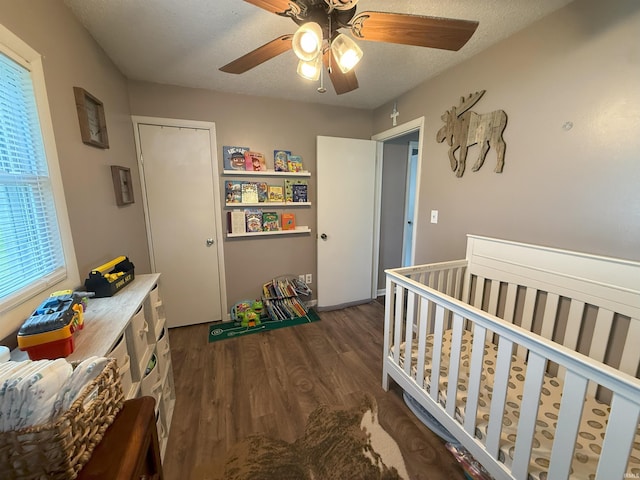 308 E Fourth St, North Webster, IN 46555 - bedroom featuring dark wood-style floors, ceiling fan, a crib, and a textured ceiling