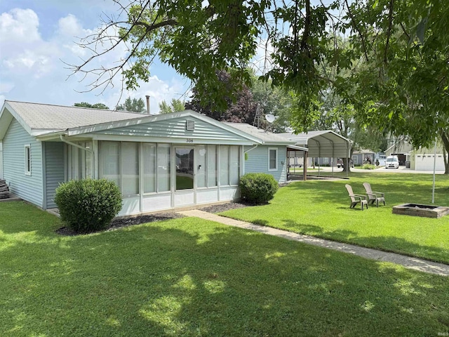 308 E Fourth St, North Webster, IN 46555 - back of property featuring a detached carport, a yard, a sunroom, and roof with shingles