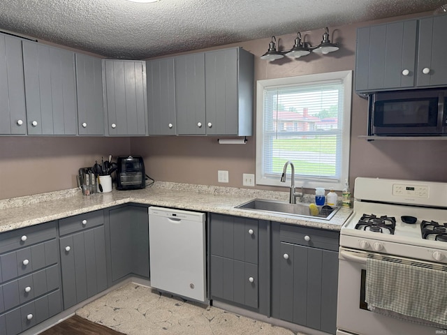 308 E Fourth St, North Webster, IN 46555 - kitchen featuring white appliances, gray cabinets, a textured ceiling, and light countertops