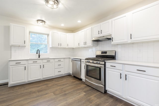 1725 Rainbow Bend Blvd, Elkhart, IN 46514 - kitchen with stainless steel appliances, under cabinet range hood, dark wood-style flooring, light countertops, and white cabinets