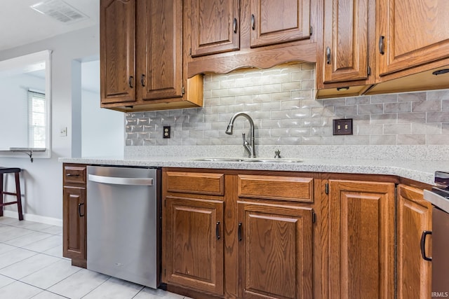 4301 W Friar Dr, Muncie, IN 47304 - kitchen with stainless steel dishwasher, light tile patterned floors, decorative backsplash, and brown cabinetry