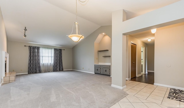 4301 W Friar Dr, Muncie, IN 47304 - unfurnished living room with vaulted ceiling, light tile patterned flooring, and light colored carpet