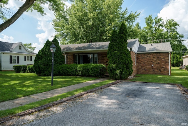 604 W 10th St, Jonesboro, IN 46938 - view of front of home with brick siding, a front lawn, and a shingled roof