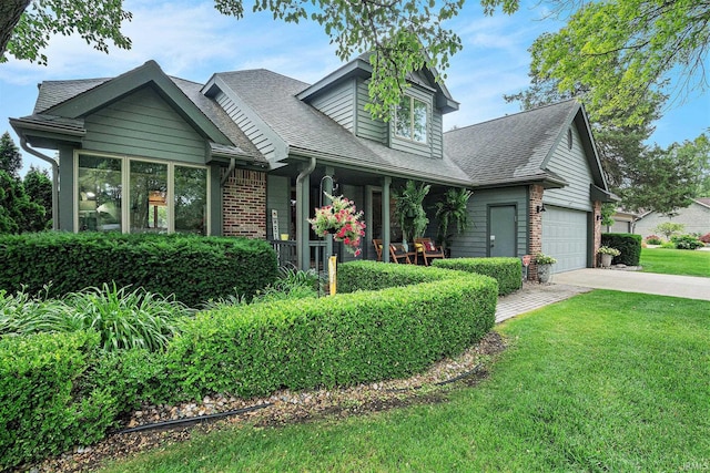 54454 Heron Cove Ln, Elkhart, IN 46516 - view of front facade with covered porch, driveway, a front yard, brick siding, and a shingled roof