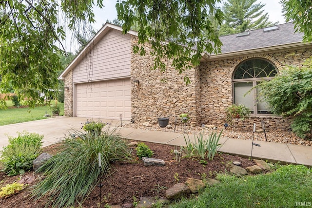 4365 N Maple Grove Rd, Bloomington, IN 47404 - view of front of home with a garage, concrete driveway, stone siding, and a shingled roof