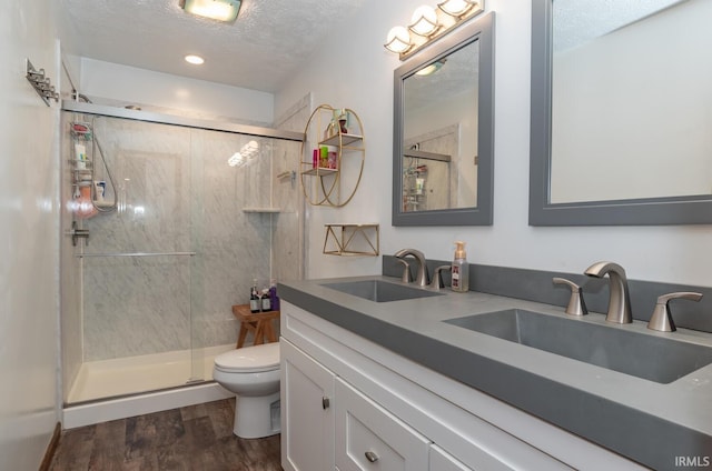 4365 N Maple Grove Rd, Bloomington, IN 47404 - bathroom featuring a textured ceiling, wood finished floors, a shower stall, and double vanity