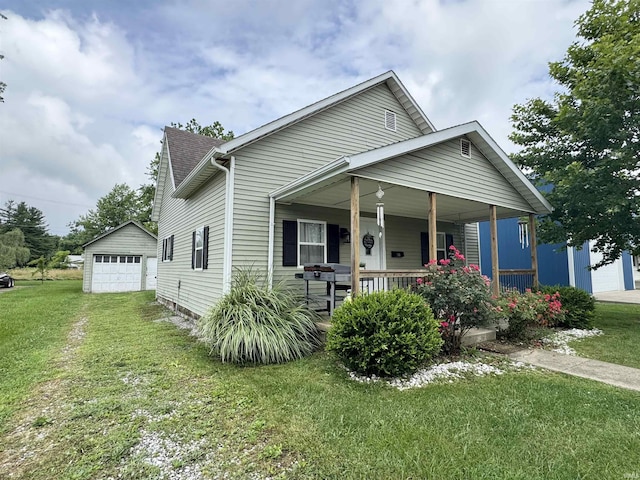 740 NW 3rd St, Linton, IN 47441 - view of front facade with a porch, a front yard, a detached garage, and an outbuilding
