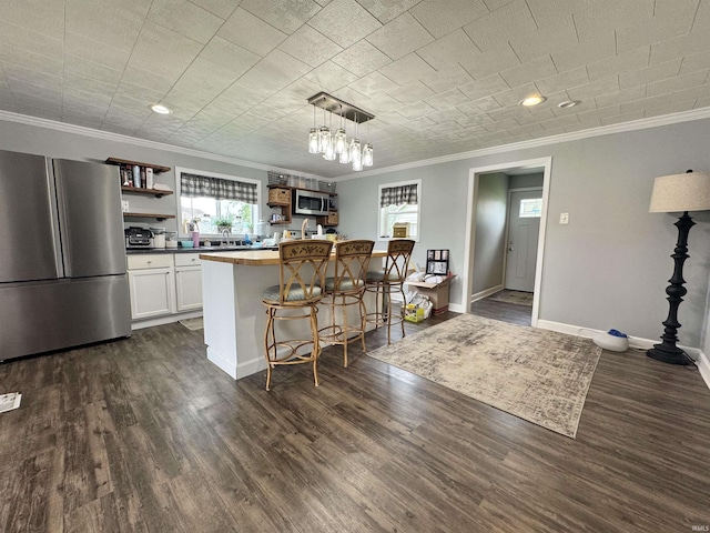 740 NW 3rd St, Linton, IN 47441 - kitchen featuring appliances with stainless steel finishes, open shelves, ornamental molding, dark wood-style flooring, and a kitchen breakfast bar