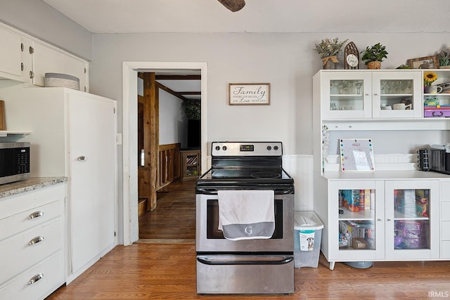 10227 E 500 S, Otterbein, IN 47970 - kitchen featuring stainless steel appliances, wood finished floors, light countertops, white cabinetry, and glass insert cabinets