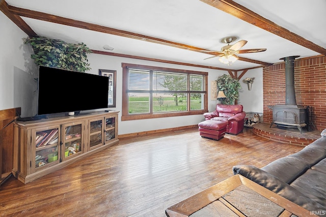 10227 E 500 S, Otterbein, IN 47970 - living room featuring a wood stove, wood finished floors, beam ceiling, ceiling fan, and ornamental molding