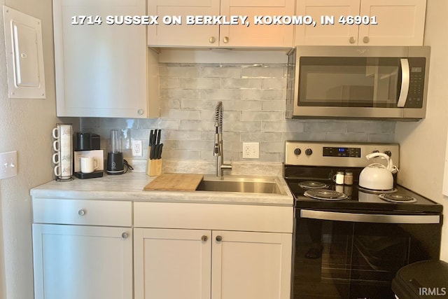 1403 Dunham On Berkley, Kokomo, IN 46901 - kitchen featuring stainless steel appliances, decorative backsplash, light countertops, and white cabinetry
