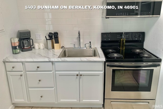 1403 Dunham On Berkley, Kokomo, IN 46901 - kitchen featuring appliances with stainless steel finishes, decorative backsplash, and white cabinets