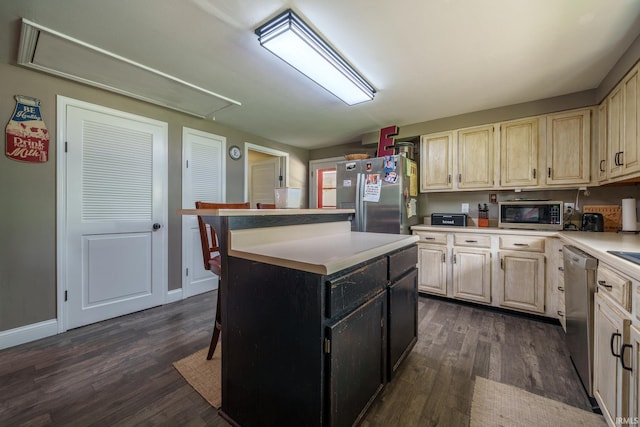 401 W Third St, Fairmount, IN 46928 - kitchen featuring appliances with stainless steel finishes, dark wood finished floors, light countertops, and a kitchen island