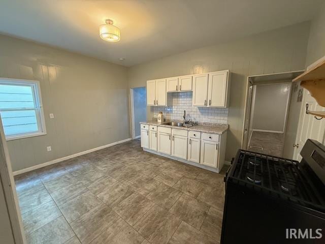 1021 W Franklin St, Evansville, IN 47710 - kitchen featuring gas stove, white cabinetry, and decorative backsplash