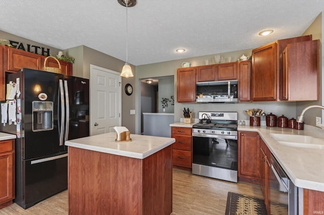 55359 Falling Water Dr, Elkhart, IN 46514 - kitchen featuring stainless steel appliances, light wood-style flooring, light countertops, a center island, and a textured ceiling