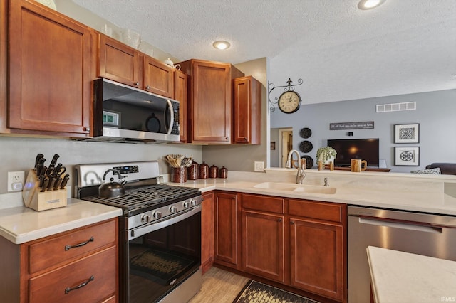 55359 Falling Water Dr, Elkhart, IN 46514 - kitchen with stainless steel appliances, light countertops, light wood-style floors, a textured ceiling, and open floor plan