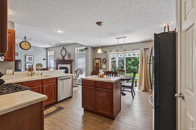 55359 Falling Water Dr, Elkhart, IN 46514 - kitchen with freestanding refrigerator, stainless steel dishwasher, wood finished floors, light countertops, and a textured ceiling