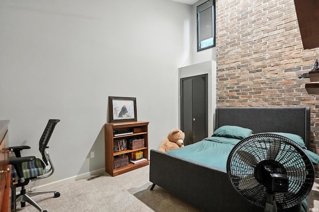 6756 Covington Creek Trl, Fort Wayne, IN 46804 - carpeted bedroom with a desk, a towering ceiling, and brick wall