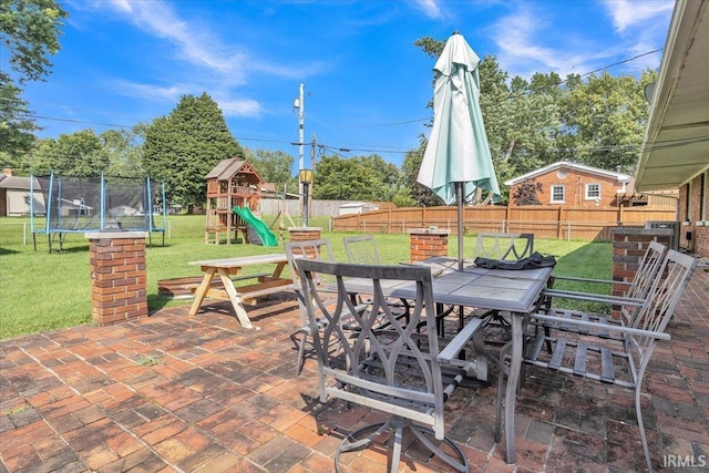 2607 Meadow Lark Ln, Evansville, IN 47720 - fenced backyard with a trampoline, outdoor dining area, a patio area, and a playground
