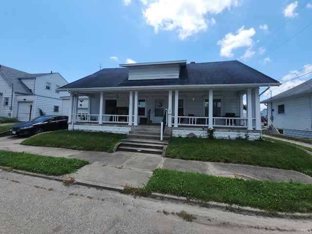 111 W Colfax St, Logansport, IN 46947 - bungalow with a porch, a front lawn, and a shingled roof