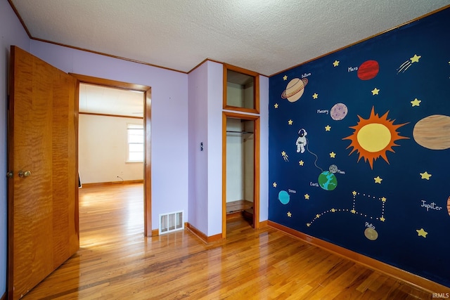 208 Chestnut St, Avilla, IN 46710 - unfurnished bedroom with wood finished floors and a textured ceiling