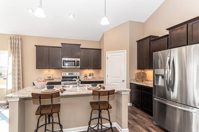 2057 Abbey Ln, Columbus, IN 47201 - kitchen featuring stainless steel appliances, dark wood-type flooring, dark brown cabinets, and a kitchen island with sink