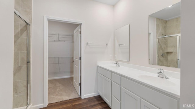 5103 Buffay Ct, New Haven, IN 46774 - bathroom featuring wood finished floors, a stall shower, double vanity, and a walk in closet