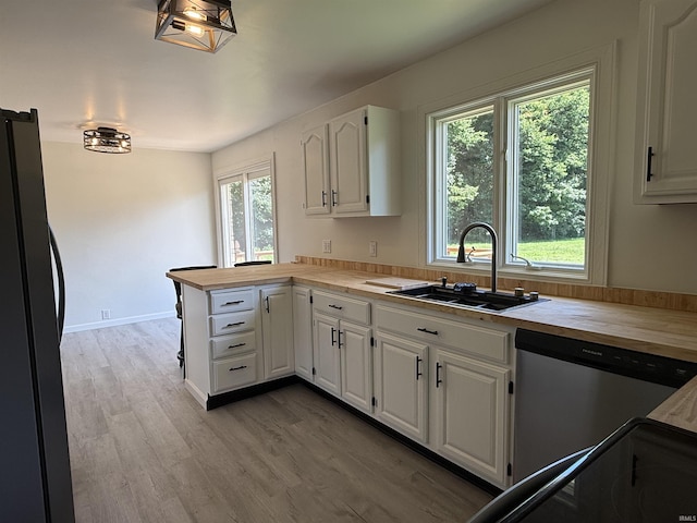 1501 S Wheeling St, Jonesboro, IN 46938 - kitchen featuring freestanding refrigerator, wood counters, a peninsula, dishwasher, and white cabinetry