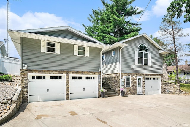11685 W 710 N, Middlebury, IN 46540 - view of front of house featuring a garage, concrete driveway, stone siding, and stairway
