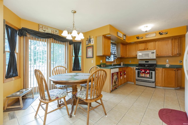 2233 Pine Creek Ct, South Bend, IN 46628 - kitchen with white microwave, stainless steel gas range oven, a chandelier, and light tile patterned floors
