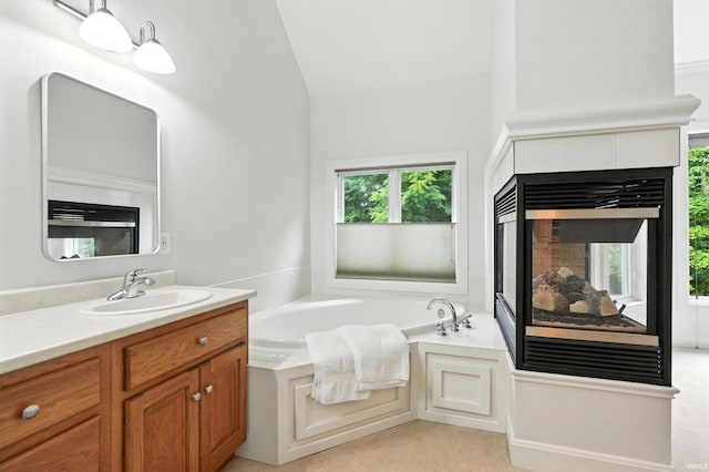 118 Royal Crest Dr, Fort Wayne, IN 46814 - bathroom with vanity, a garden tub, a fireplace, healthy amount of natural light, and lofted ceiling