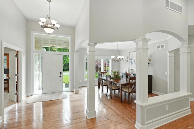 118 Royal Crest Dr, Fort Wayne, IN 46814 - entryway featuring a high ceiling, a chandelier, arched walkways, light wood-style floors, and ornate columns