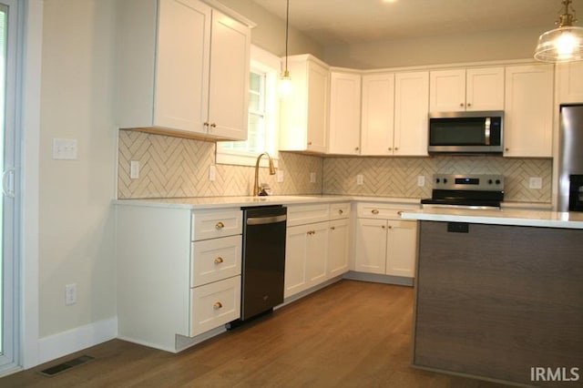 1001 E Clinton St, Frankfort, IN 46041 - kitchen with stainless steel appliances, light countertops, dark wood-type flooring, and white cabinetry