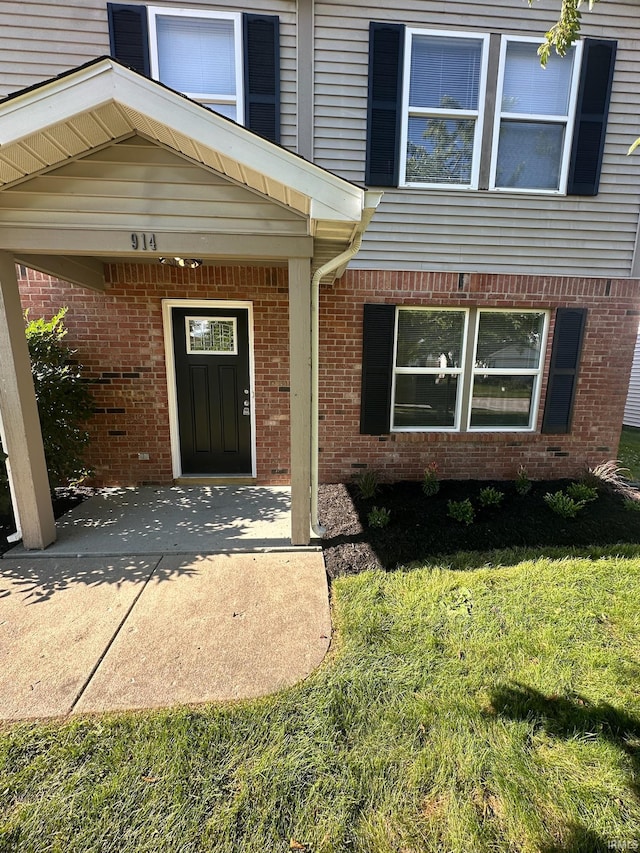 914 Braxton Dr N, Lafayette, IN 47909 - view of exterior entry featuring a lawn and brick siding