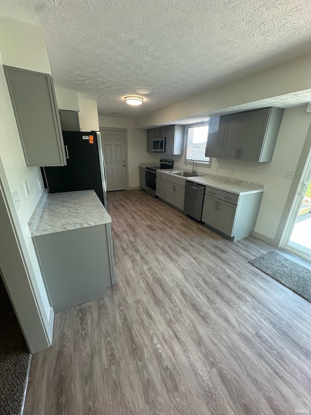 914 Braxton Dr N, Lafayette, IN 47909 - kitchen featuring stainless steel appliances, a textured ceiling, gray cabinets, light wood-style floors, and light countertops