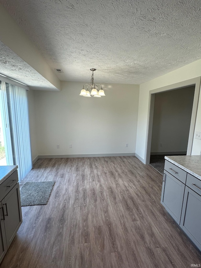 914 Braxton Dr N, Lafayette, IN 47909 - unfurnished dining area featuring dark wood finished floors, a chandelier, and a textured ceiling