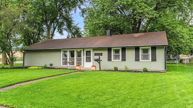 4144 Wenonah Ln, Fort Wayne, IN 46809 - ranch-style home featuring a trampoline, a front yard, and a shingled roof