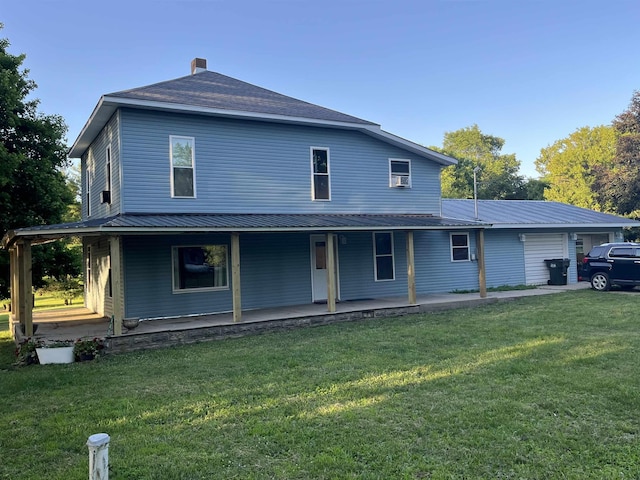 640 N Flint Rd, Angola, IN 46703 - rear view of property featuring a porch, a lawn, a metal roof, an attached garage, and a chimney