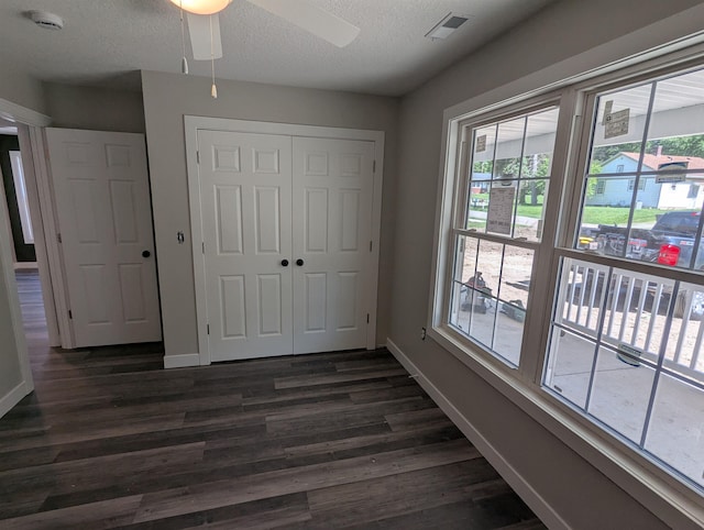 2206 24th Ave, Fort Wayne, IN 46802 - unfurnished bedroom featuring dark wood finished floors, multiple windows, a closet, a textured ceiling, and ceiling fan