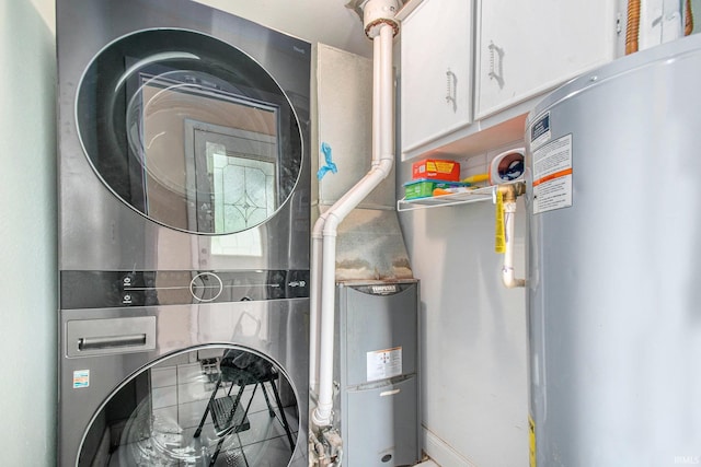 18055 Thomas Ln, Goshen, IN 46528 - laundry room featuring water heater, stacked washing machine and dryer, and cabinet space