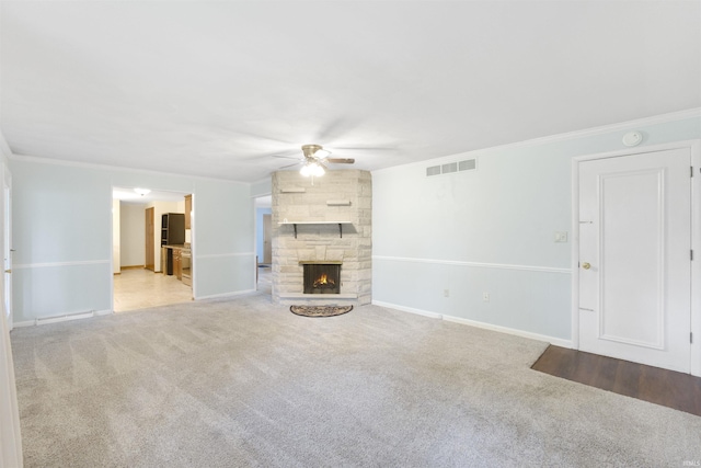 3617 Kirkfield Dr, Fort Wayne, IN 46815 - unfurnished living room featuring a ceiling fan, carpet flooring, crown molding, and a stone fireplace
